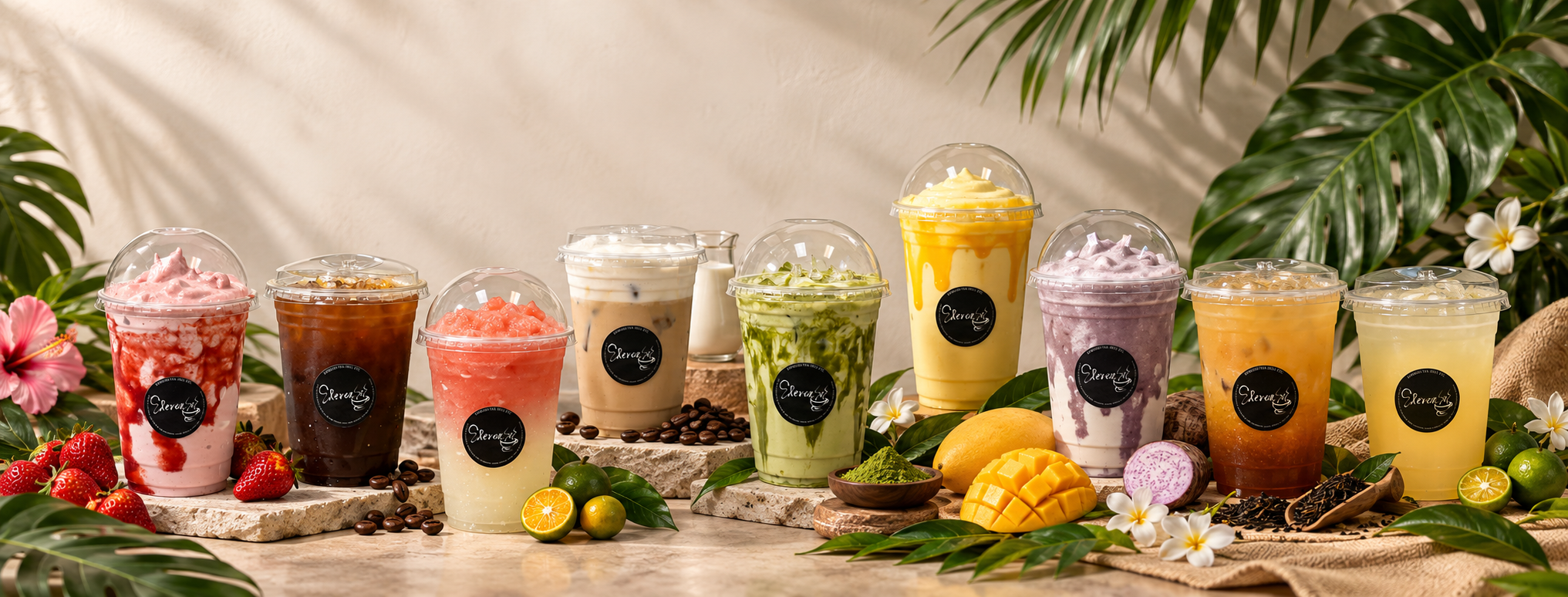 Elevenses drinks including coffee, fruit smoothies, matcha, ube, mango, tea and citrus drinks in a tropical display